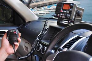 Handheld PTT speaker controls trunk radio at busy sea port during active shipping hours photo