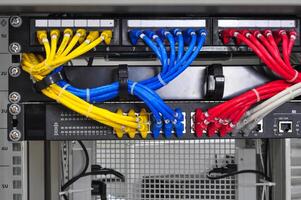 Colorful network cables connected to a patch panel in a data center during the day photo