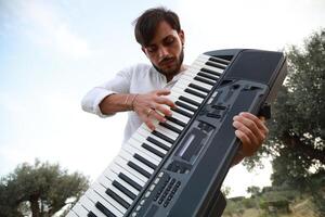 Keyboard Player Standing In Nature With Olive Trees In Calabria photo