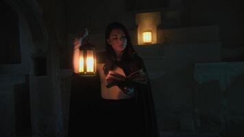 Woman Reads Mysteries On Magic Book In Ancient Cave At Night With Lantern photo
