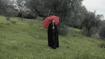 Enigmatic Woman With Red Umbrella Looks Around In A Gloomy Countryside photo