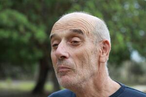 Elderly Man Smiles At An Intrigued Child In The Nature Park Outside photo