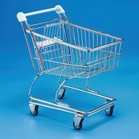 Shiny chrome miniature shopping cart against a vibrant blue background. photo