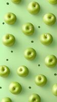 Vibrant green apples arranged in a symmetrical pattern on a soft green background with scattered dots. photo