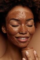 Smiling woman with clay face mask enjoying a skincare routine, eyes closed. photo