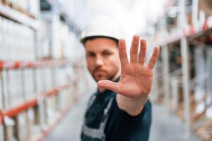 Stop here. No pass. Employee in uniform is working in the storage at daytime. photo