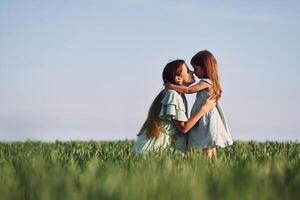 Moment of tenderness. Mother and daughter have fun outdoors on the field at summer.., photo