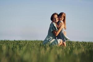 Moment of tenderness. Mother and daughter have fun outdoors on the field at summer.. photo
