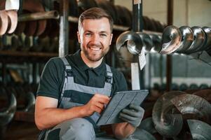 Manager is using digital tablet. .Man in uniform is in workstation developing details of agriculture technique photo