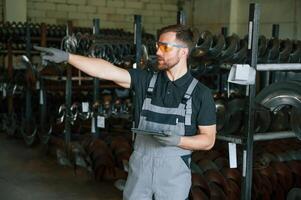 Standing with tablet. Man in uniform is in workstation developing details of agriculture technique. photo