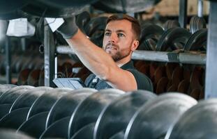 Quality test. Man in uniform is in workstation developing details of agriculture technique photo