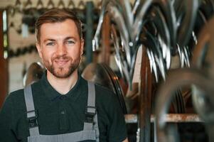 Portrait of man in uniform that is in workstation developing details of agriculture technique photo