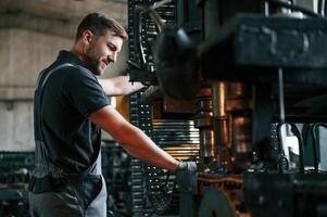 Metal processing device. Man in uniform is in workstation developing details of agriculture technique photo