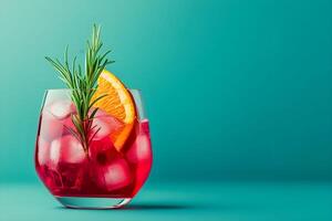 A glass of red drink with an orange slice and rosemary sprig photo