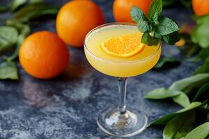 A glass of orange juice with mint leaves on top photo