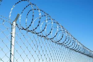 A chain link fence with razor wire on top photo