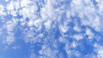 Camera move behind white fluffy clouds on blue sky at summer sunny day. Beautiful nature background. Close up Slow motion photo