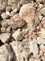 Varied textures of crushed rock aggregate in bright sunlight near a construction site photo