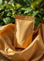 Yellow fabric bag with cosmetic cream on a background of green plants. Kraft Paper Pouch Mockup photo