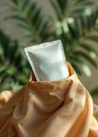 Cream tube in a bag on the background of palm leaves. Product Packaging Mockup photo