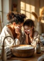 Beautiful young mother and daughter in bathrobes looking at each other and smiling while having skincare routines in the morning at home. Mother and Daughter Spa Day photo