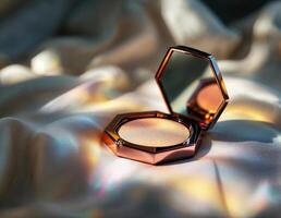 Eye shadow in gold box on white silk background. Selective focus. Rose Gold Highlighter Compact photo