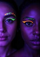 Close-up portrait of two beautiful African American women with fluorescent make-up. Neon Glow Makeup photo