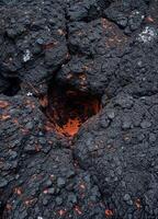 Volcanic black lava textures with flames on the background. Volcanic Lava Crater photo