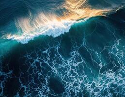 Aerial view of ocean waves crashing on shore. Top view from drone. Ocean Wave at Sunset photo