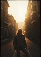 A young man in a jacket walks along a city street at sunset. Golden Hour Stroll photo