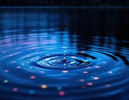 Water drop on the surface of the water with ripples and reflection. Water Droplet Ripple photo