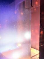 Close up view of a glass wall in a room with lights. Scratched Glass Surface photo