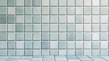 A clean tiled wall with square tiles arranged in a grid pattern. photo