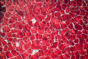 Red Tiled Pool Water Surface with Light Refraction photo