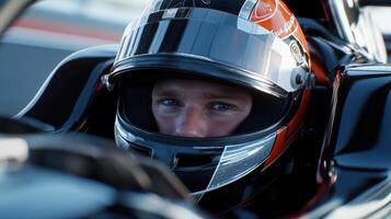 A man in a racing car is looking at the camera photo