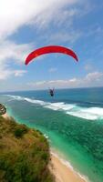 FPV Shot Of Paragliders Gliding Over Turquoise Ocean And Beach In Bali Indonesia video