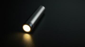 A flashlight is shown on a black surface photo