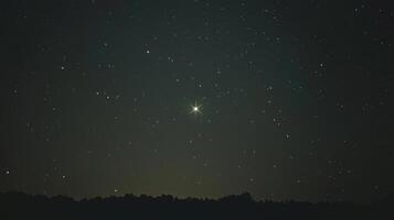 A star shines brightly in the night sky photo