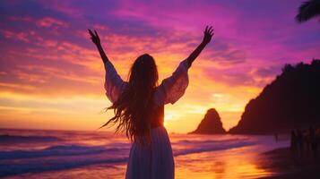 Woman with arms up in the air at sunset photo