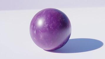 A purple marble sitting on a white surface photo