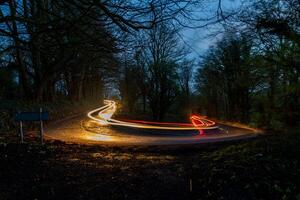 Curved road with light trails at twilight photo