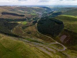 Winding road leading through green valley in wales photo