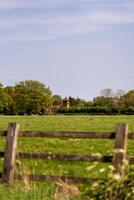 Idyllic country house viewed over rustic fence photo