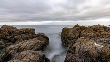 Water rushing between rocks on cloudy day in scotland photo