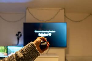 Man using remote control, watching television at home photo