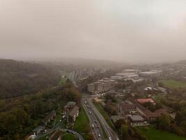 Fog covering residential neighborhood with road and trees in autumn photo