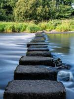 Stepping stones crossing a flowing river in scotland photo