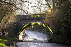 Low bridge sign indicating height restriction on a country road photo