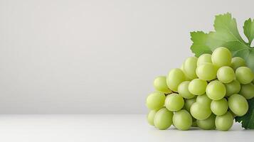 Fresh Green Grapes with Leaves on a Simple White Background photo