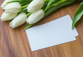 Fresh White Tulips with Blank Cards on Wooden Surface photo